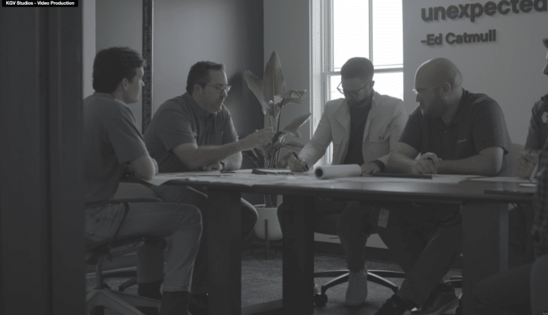 A group of three people looking through blueprints